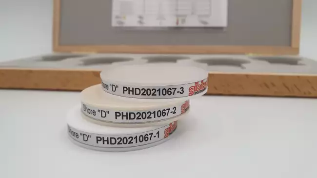 samples shore d: Zertifizierte Proben für die regelmäßige Überprüfung von Shore-D-Härteprüfern. Detailansicht der Proben mit eindeutigem Identifikationsetikett.